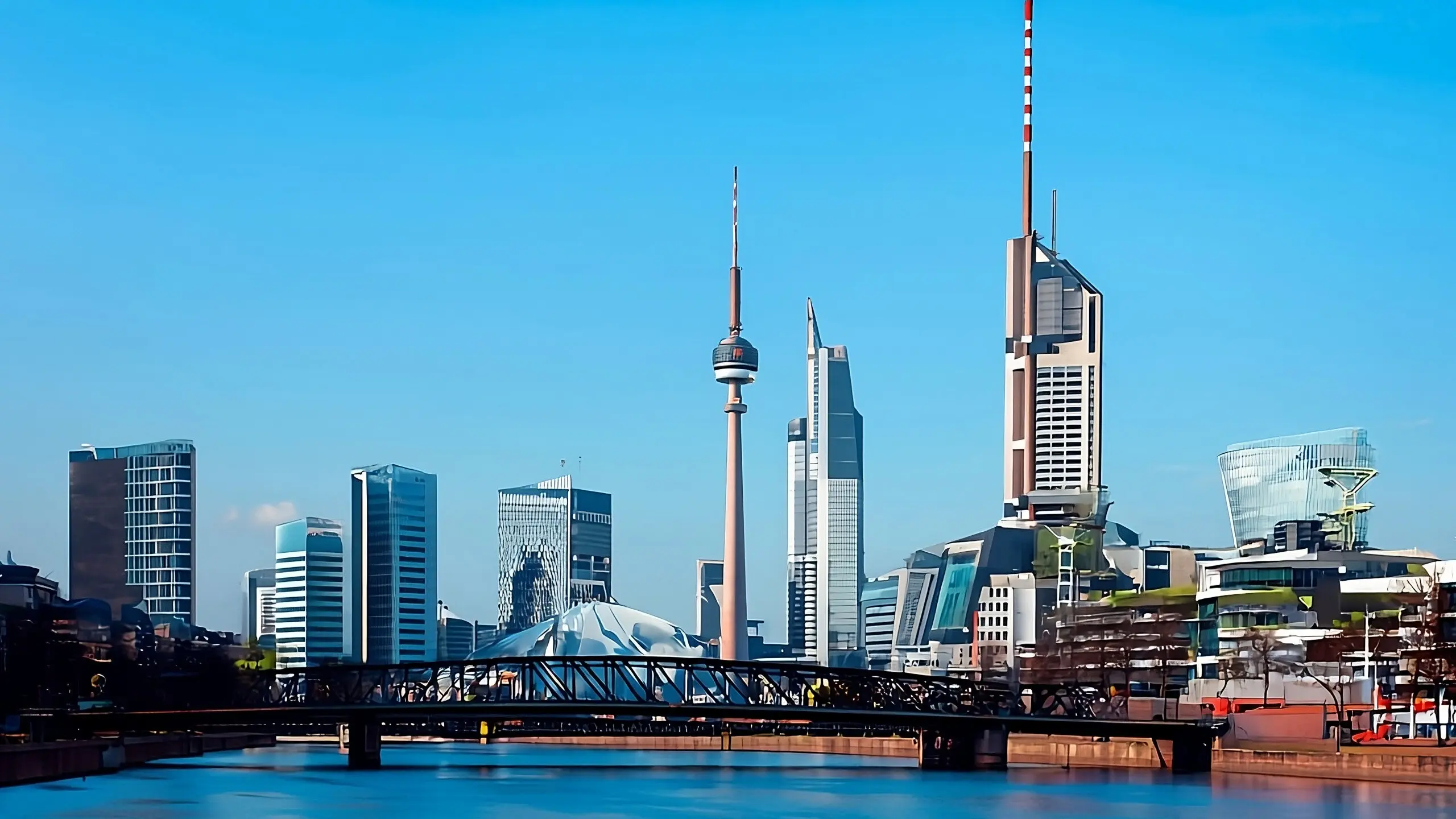 EINE BR&Uuml;CKE &Uuml;BER WASSER MIT EINER SKYLINE DER STADT